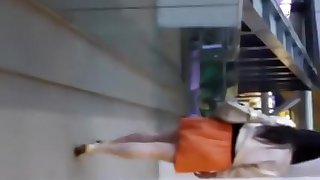 Woman in orange skirt upskirted